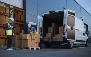 pracownicy centrum logistycznego przygotowują paczki do transportu