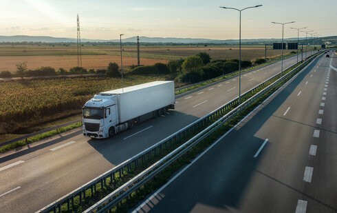 firma realizuje usługę transportu międzynarodowego - ciężarówka jedzie autostradą w stronę odprawy celnej